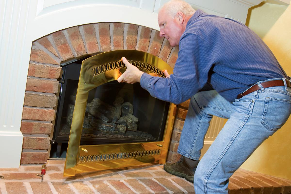 man Installs a Gas Fireplace Insert