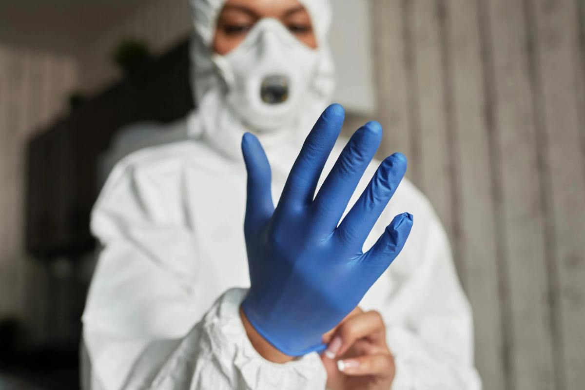 hand-of-a-person-wearing-a-latex-glove